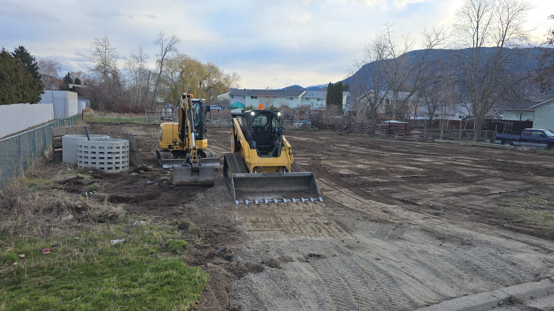 Excavator and skid steer clearing a residential lot for subdivision development