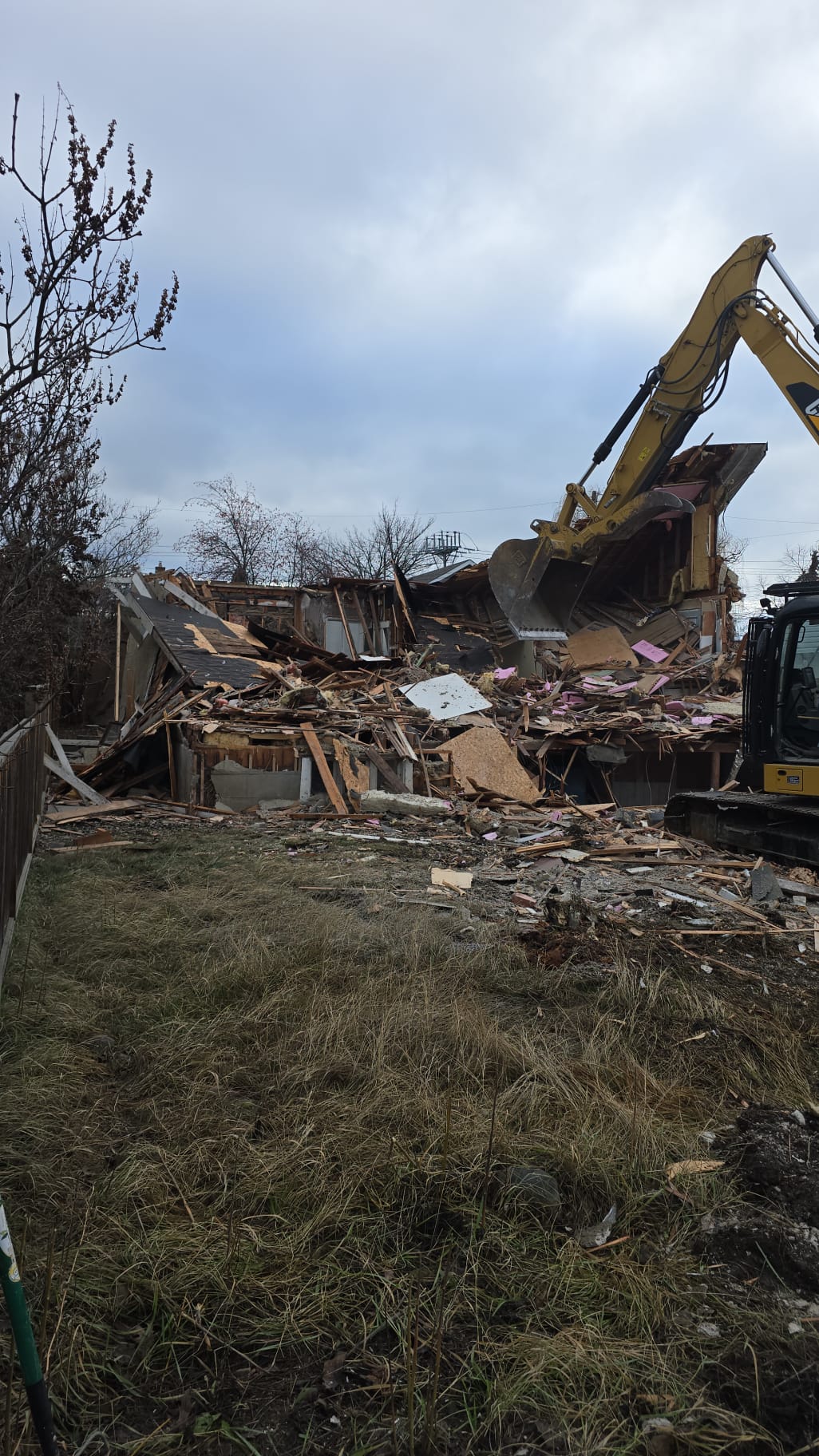 CAT excavator demolishing a house in Okanagan BC