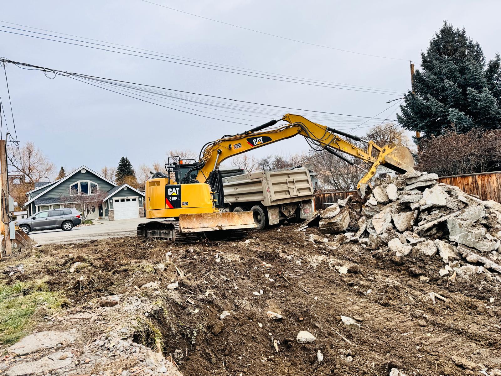 CAT excavator demolishing a house structure in Okanagan BC